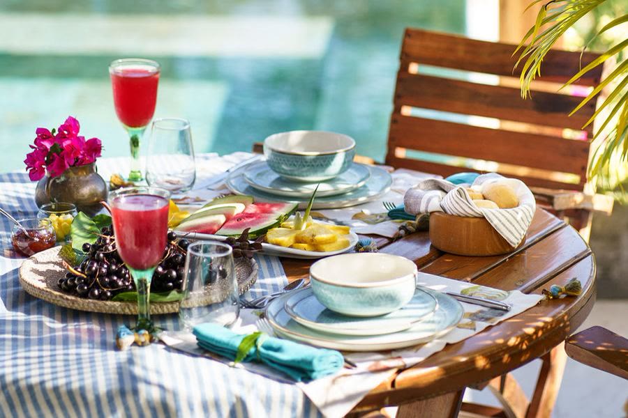Table du petit-déjeuner dressée au bord de la piscine d'une villa