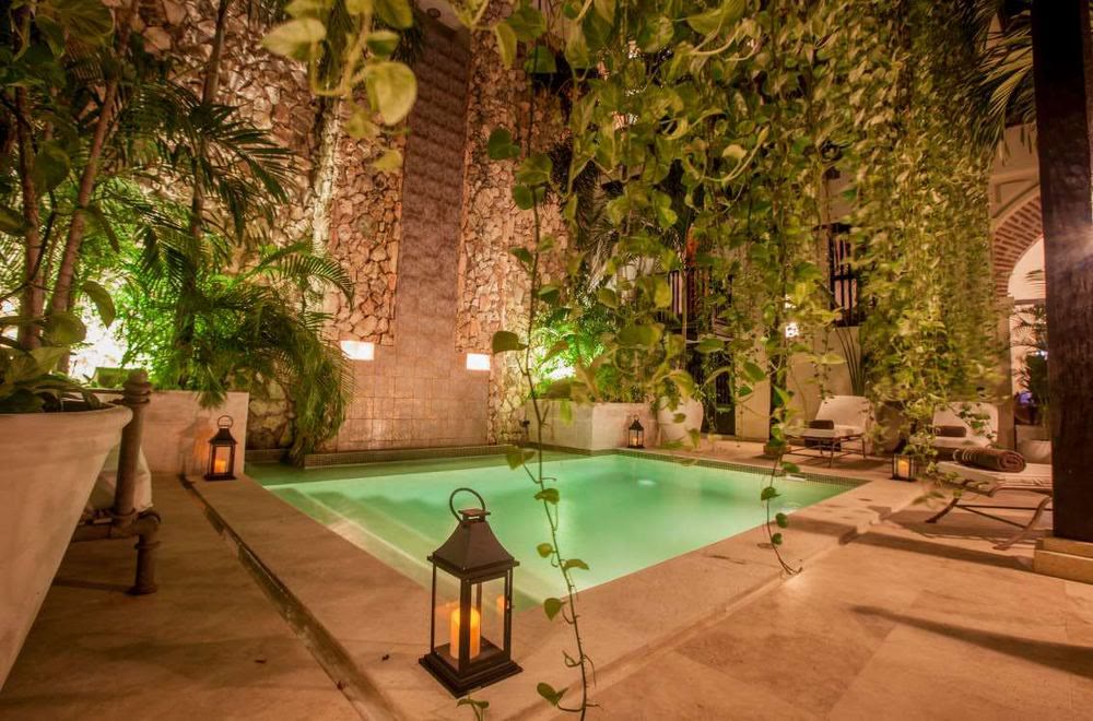 Piscine d'un patio illuminée le soir par des lanternes